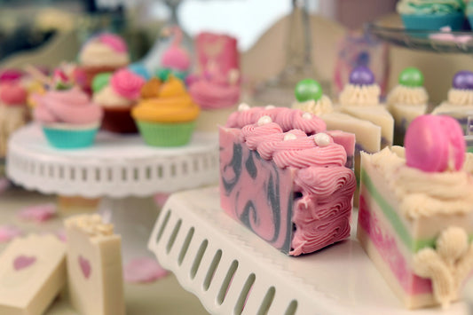Slices of colorful cake soap in the foreground and cupcake soap in the background