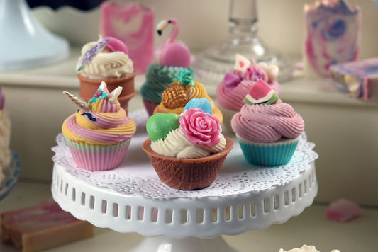 multiple "flavors" of cupcake soap sitting on top of a cake stand