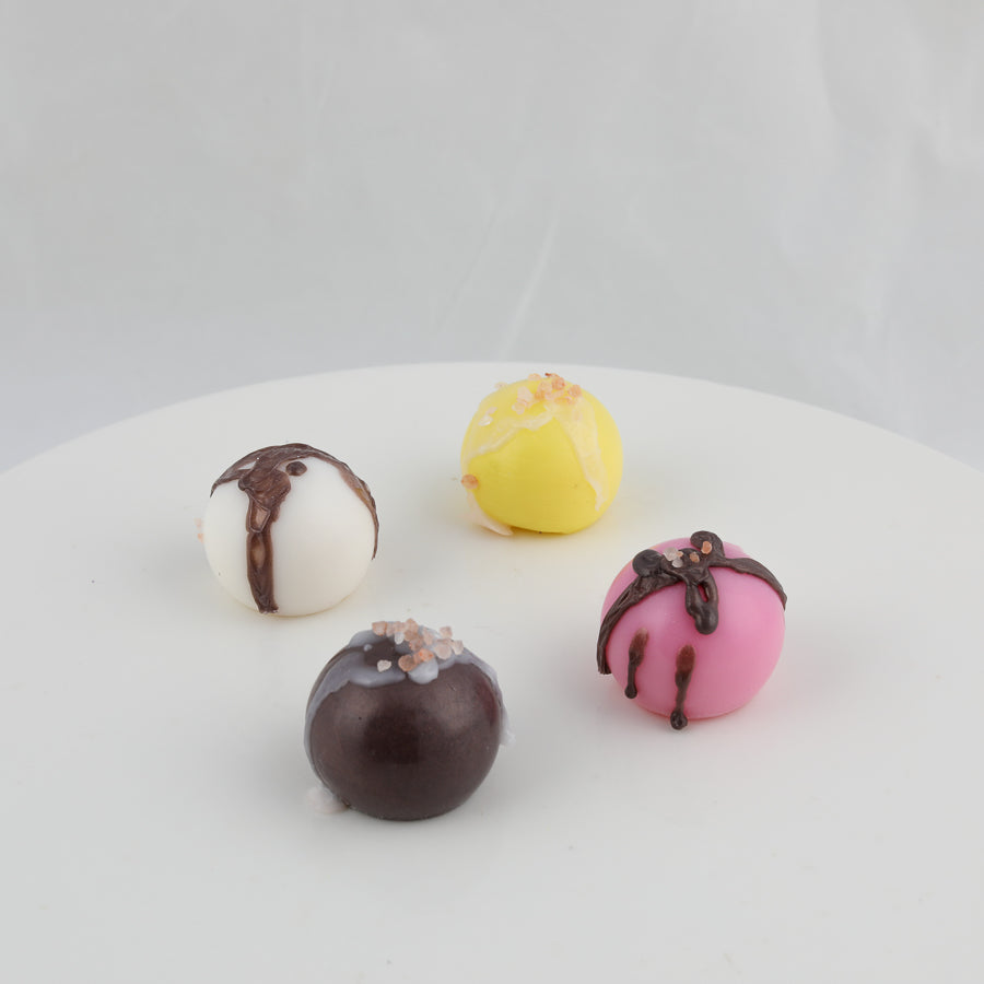 chocolate truffle looking soap. Colors include pink with brown stripes, brown with sprinkles, white with brown stripes, and yellow with sprinkles