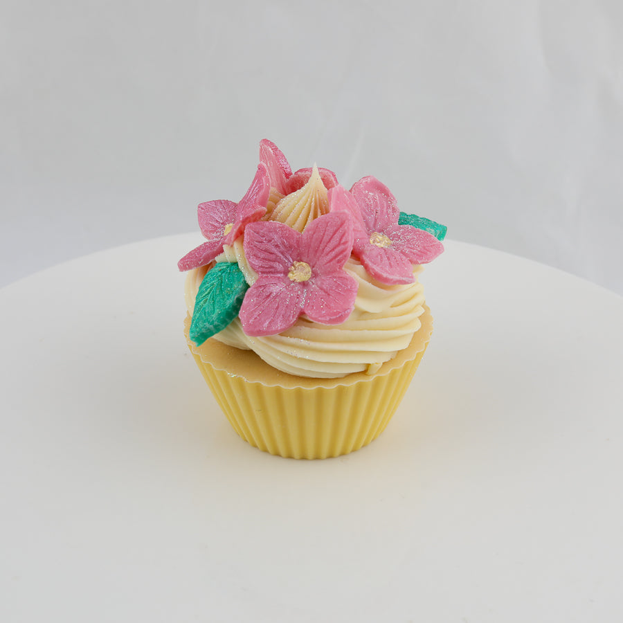 yellow and cream colored cupcake shaped soap with pink flowers and green leaves on top