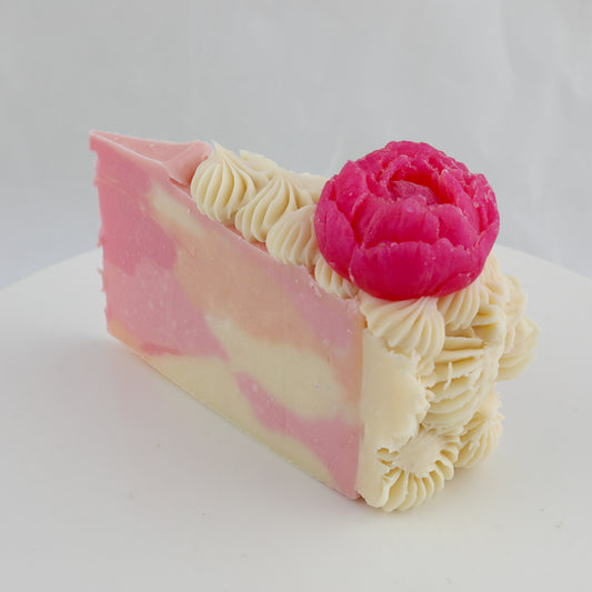 cream and pink colored cake shaped soap with a bright pink peony on top