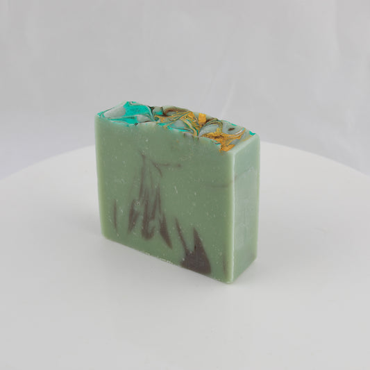 General use bar of soap with green, brown, gold, and turquoise swirls