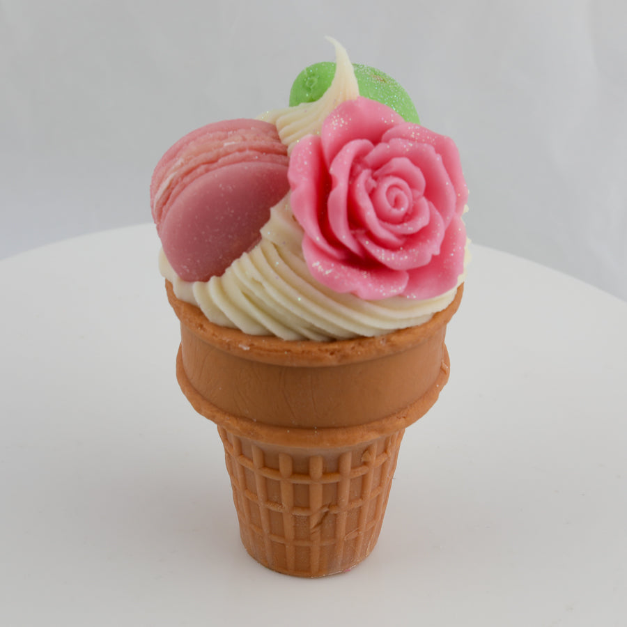 cream and brown waffle cone with a pink rose, pink macaroon on top