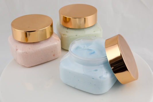 jars of bath creme in pink, green, and blue colors with copper tops