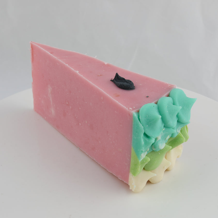 pink, green, and turquoise colored cake shaped  soap that is decorated like a watermelon